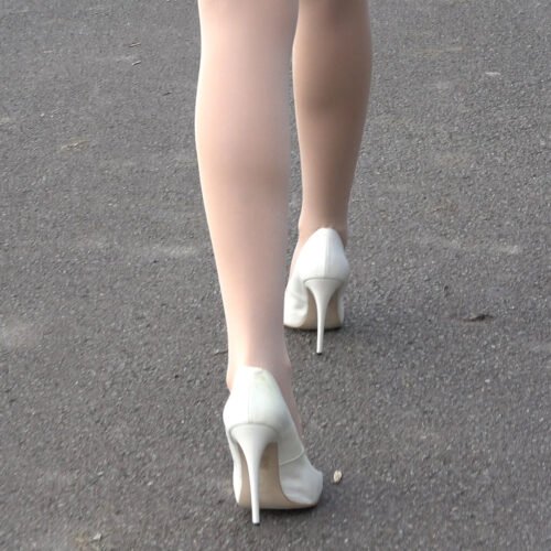 Walking slowly wearing very high thin white heels